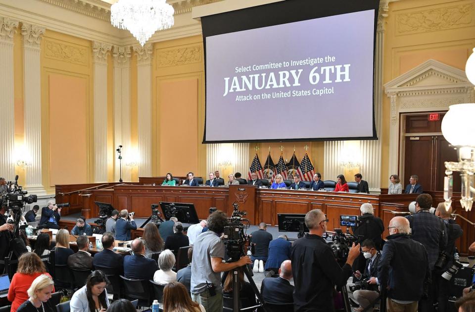 The words "January 6th" are prominently displayed on a projection screen placed above the House select committee members during the panel's first public hearing on June 9, 2022.