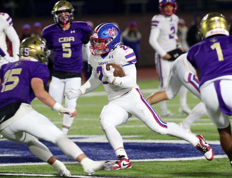 Carmel's Tristan Werlau (22) looks for some running room in the Christian Brothers Academy defense during the Class AA state semifinal playoff game at Middletown High School Nov. 25, 2023.