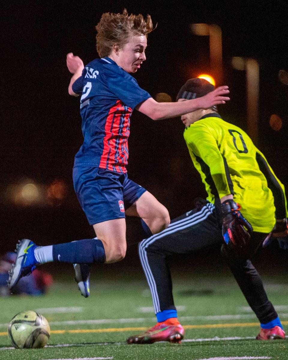 Silas forward Joseph Nicholas attempts to dribble around Lakes goalkeeper Jonathan Bieber during the second half of a Pierce County League game on Thursday, March 31, 2022, at Silas High School in Tacoma, Wash.