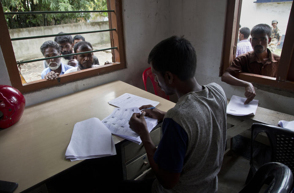 In this Aug. 31, 2019 photo, villagers wait to check their names in the final list of National Register of Citizens in Morigaon district, Assam, India. About 1.9 million people were left out of the National Register of Citizens _ a mammoth exercise to weed out illegal mainly Bangladeshi immigrants from Assam’s more than 32 million people. (AP Photo/Anupam Nath)