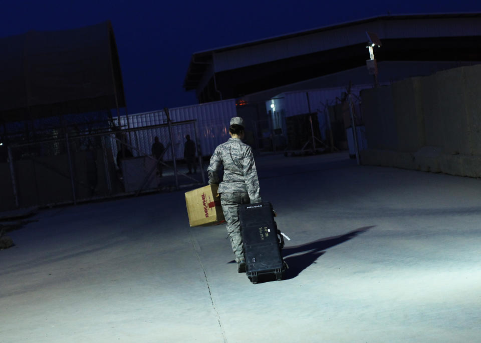 U.S. Air Force Major Stacie Shafran carries her luggage to a loading paddock while waiting for her departure from Iraq at the former U.S. Sather Air Base near Baghdad, Iraq December 14, 2011. The former base that is currently still operational was handed over to the Baghdad Diplomatic Support Center run by the State Department on December 1st. REUTERS/Shannon Stapleton