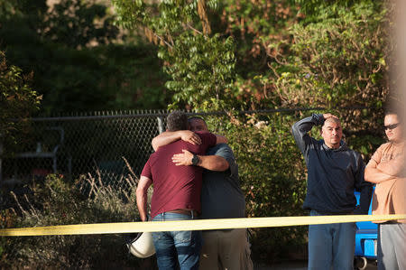 A Trader Joe's employee embraces a friend in a parking lot near a Trader Joe's store where a hostage situation unfolded in Los Angeles, California, July 21, 2018. REUTERS/Andrew Cullen