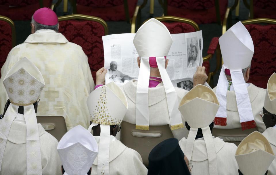 A bishop reads a paper in St. Peter's Square at the Vatican, Sunday, April 27, 2014. Tens of thousands of people have filled St. Peter's Square for a historic day of four popes, with Popes Francis and Benedict XVI honoring John XXIII and John Paul II by declaring them saints in the first ever canonization of two pontiffs.(AP Photo/Gregorio Borgia)