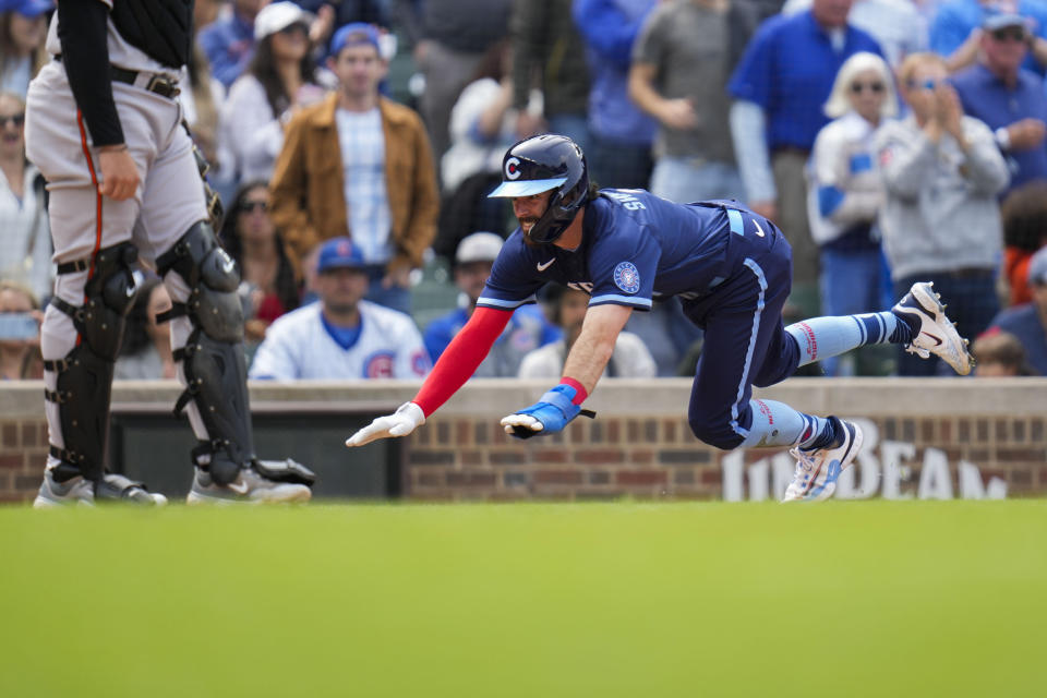 Chicago Cubs' Dansby Swanson dives into home base to score during the sixth inning of a baseball game against the Baltimore Orioles, Friday, June 16, 2023, in Chicago. (AP Photo/Erin Hooley)