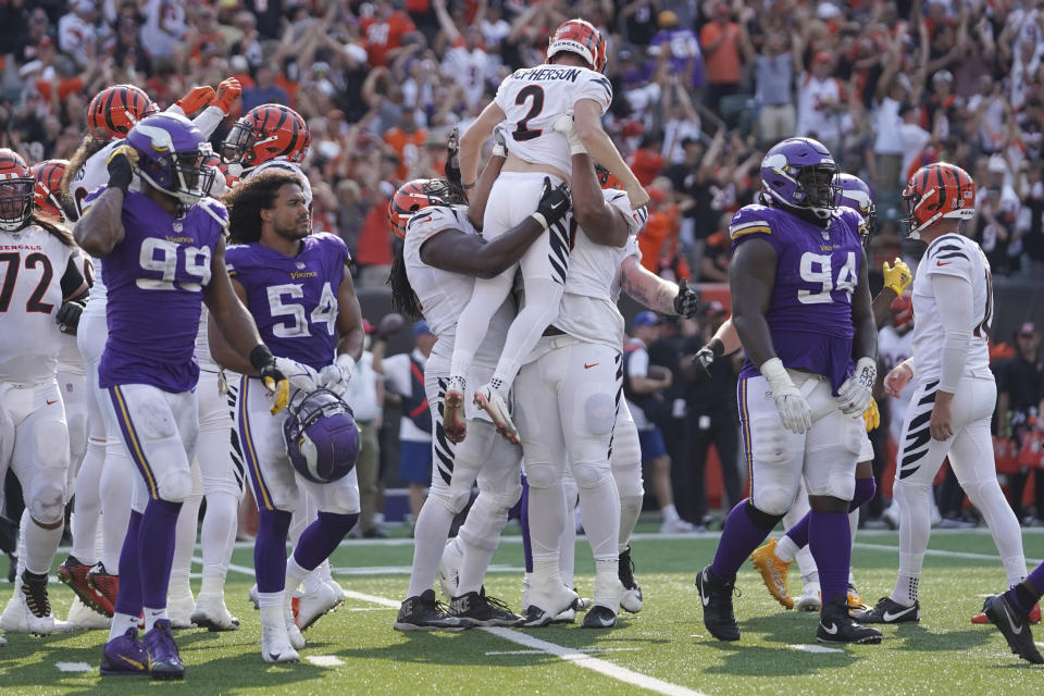 The Minnesota Vikings walk off the field as the Cincinnati Bengals hoist their kicker Cincinnati Bengals kicker Evan McPherson (2) after he made a field goal to win during overtime of an NFL football game, Sunday, Sept. 12, 2021, in Cincinnati. The Bengals won 27-24. (AP Photo/Jeff Dean)