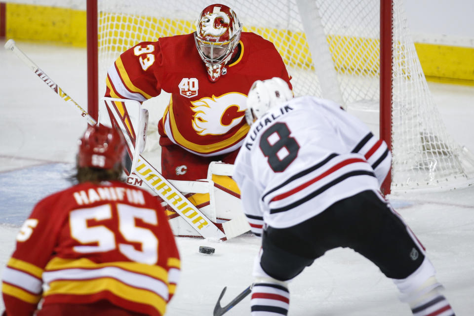 Chicago Blackhawks' Dominik Kubalik, right, has his shot blocked by Calgary Flames goalie David Rittich during the first period of an NHL hockey game Tuesday, Dec. 31, 2019, in Calgary, Alberta. (Jeff McIntosh/The Canadian Press via AP)