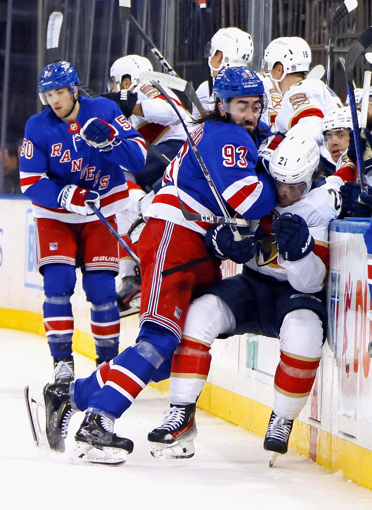 NEW YORK, NEW YORK - MARCH 04: Mika Zibanejad #93 of the New York Rangers hits Nick Cousins #21 of the Florida Panthers into the boards during the third period at Madison Square Garden on March 04, 2024 in New York City. The Panthers defeated the Rangers 4-2.