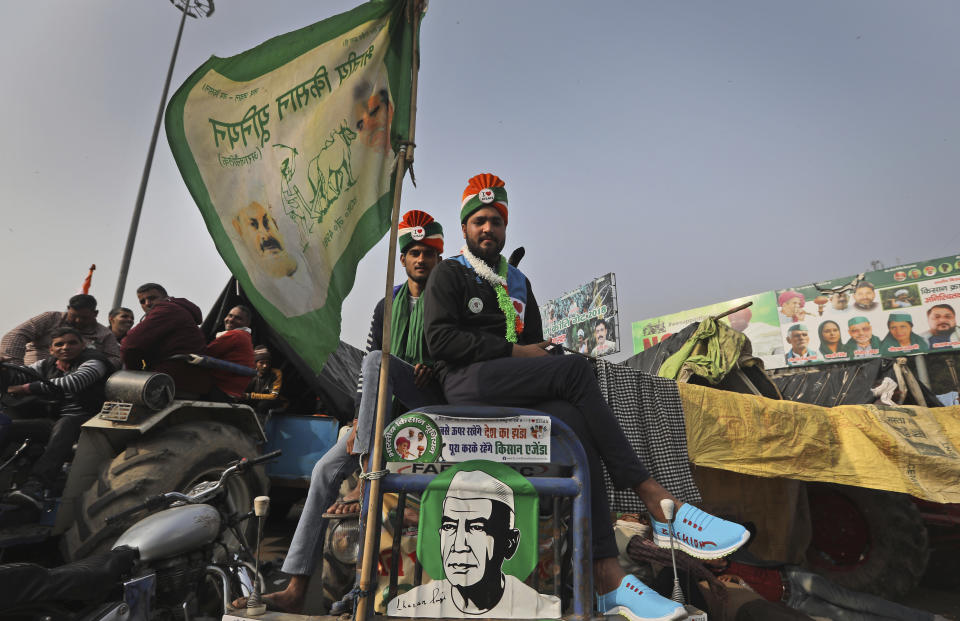 Indian farmers sit on their tractors after arriving at the Delhi-Uttar Pradesh border for Tuesday's tractor rally in New Delhi, India, Monday, Jan. 25, 2021. Thousands of farmers gathered on the borders of Delhi for a massive tractor rally on Tuesday against the three contentious farm laws when India will celebrate its Republic day with a military and cultural parade. The two-month-old old blockade of highways connecting the capital with the country's north continues as the talks have remained deadlocked with the government refusing to scrap the new agricultural reform laws which the farmers say will benefit large corporations. (AP Photo/Manish Swarup)