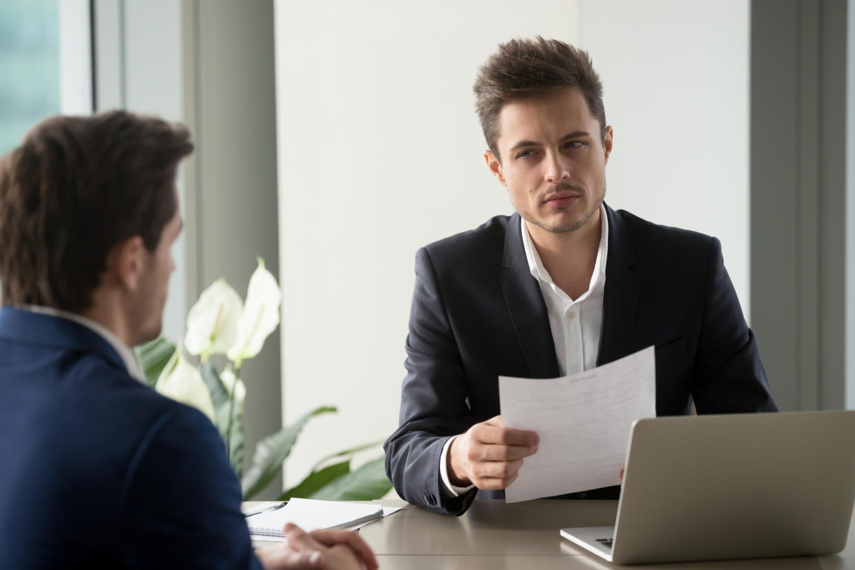 Distrustful businessman holding document at meeting, looking at partner with doubt suspicion, recruiter reads bad resume, caught applicant being dishonest at job interview, shady deal, contract fraud