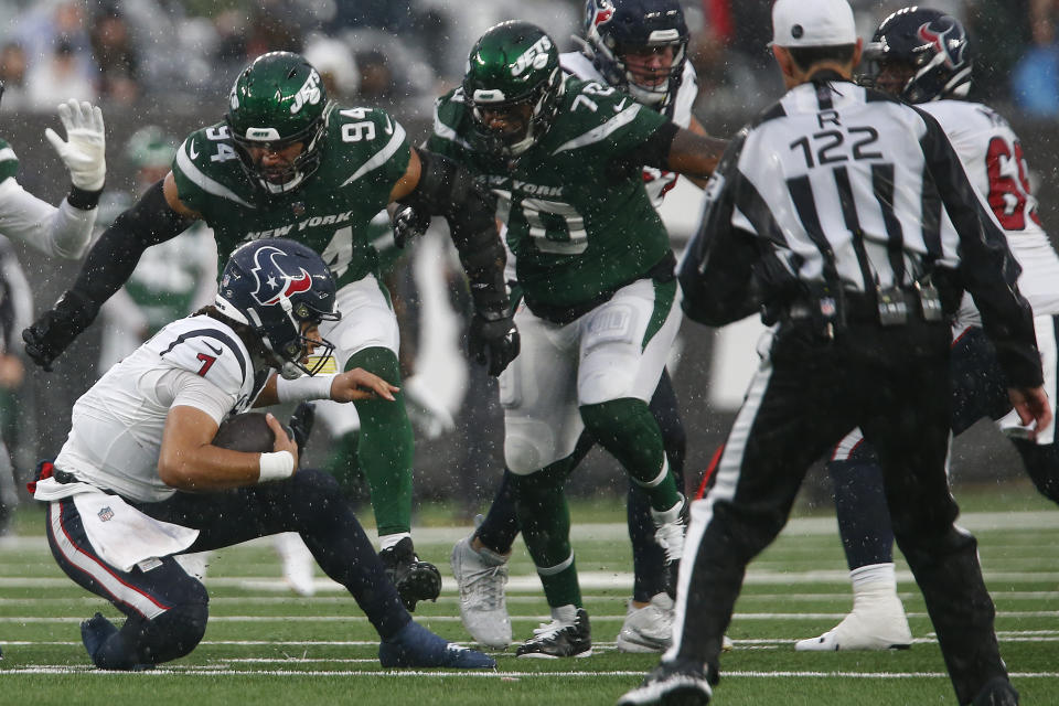 Houston Texans quarterback C.J. Stroud (7) falls to the turf under pressure from New York Jets defensive end Solomon Thomas (94) and defensive tackle Quinton Jefferson (70) during the second quarter of an NFL football game, Sunday, Dec. 10, 2023, in East Rutherford, N.J. (AP Photo/John Munson)