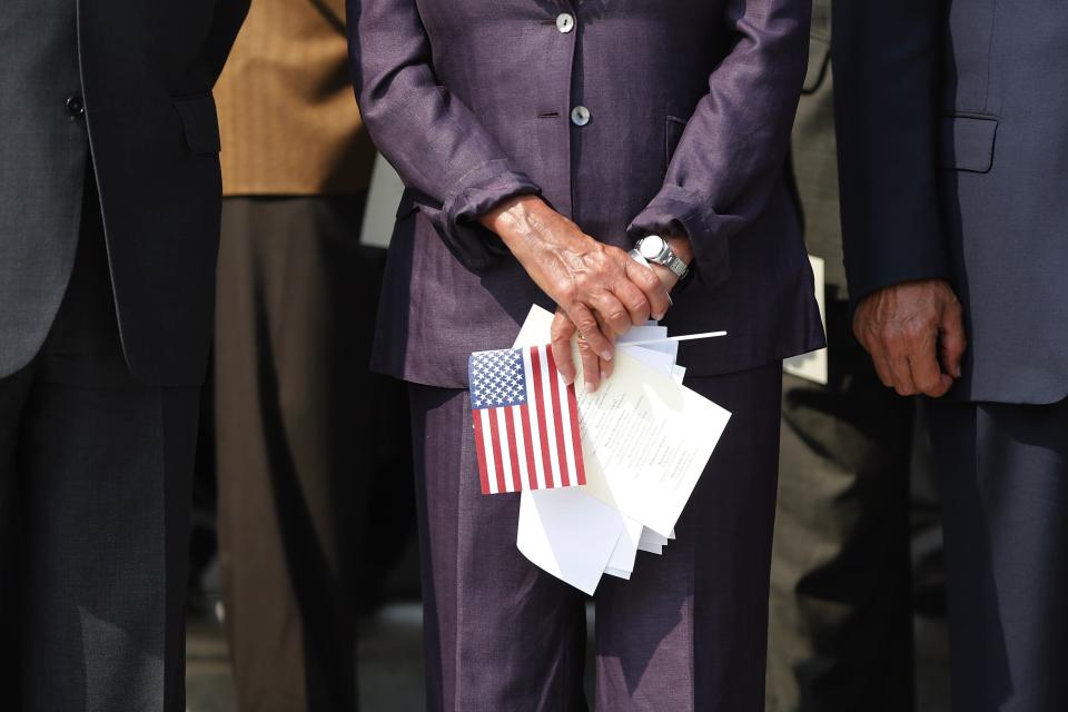 U.S. House Minority Leader Nancy Pelosi (D-CA) (C) holds a U.S. flag during a remembrance of lives lost in the 9/11 attacks, on the steps of the U.S. Capitol in Washington, September 11, 2013. Bagpipes, bells and a reading of the names of the nearly 3,000 people killed when hijacked jetliners crashed into the World Trade Center, the Pentagon and a Pennsylvania field marked the 12th anniversary of the September 11 attacks in 2001. REUTERS/Jonathan Ernst