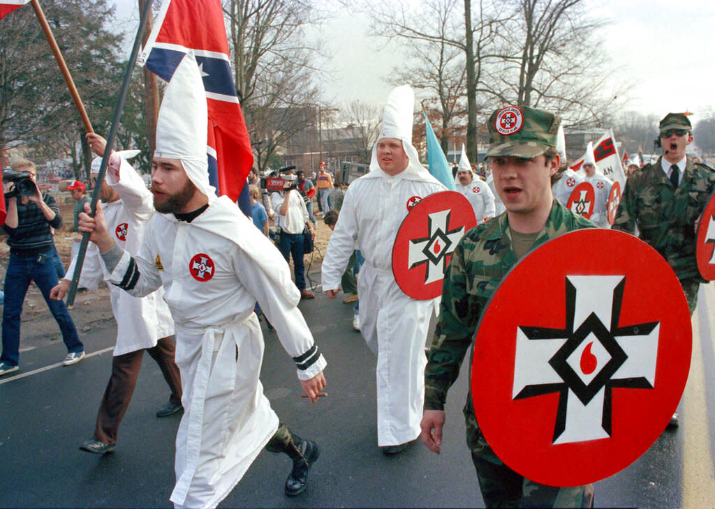 In this 1986 file photo, members of the Ku Klux Klan march as they demonstrate against the first national observance of <span class="caas-xray-inline-tooltip"><span class="caas-xray-inline caas-xray-entity caas-xray-pill rapid-nonanchor-lt" data-entity-id="Martin_Luther_King_Jr." data-ylk="cid:Martin_Luther_King_Jr.;pos:1;elmt:wiki;sec:pill-inline-entity;elm:pill-inline-text;itc:1;cat:Writer;" tabindex="0" aria-haspopup="dialog"><a href="https://search.yahoo.com/search?p=Martin%20Luther%20King%20Jr." data-i13n="cid:Martin_Luther_King_Jr.;pos:1;elmt:wiki;sec:pill-inline-entity;elm:pill-inline-text;itc:1;cat:Writer;" tabindex="-1" data-ylk="slk:Martin Luther King Jr.;cid:Martin_Luther_King_Jr.;pos:1;elmt:wiki;sec:pill-inline-entity;elm:pill-inline-text;itc:1;cat:Writer;" class="link ">Martin Luther King Jr.</a></span></span>'s birthday. (AP Photo/Mark Humphrey)