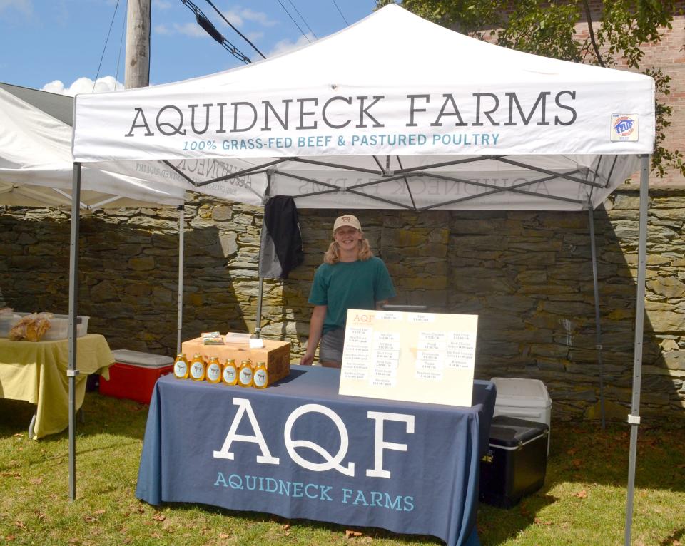 Emily Watne, sales manager at Portsmouth’s Aquidneck Farms, operates a booth at the Aquidneck Farmers Market on Memorial Boulevard in Newport.