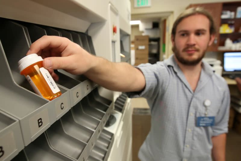 FILE PHOTO: Pharmacist technician McKay Kleinman, holds a filled prescription bottle that came out from an automated drug dispensing machine at the Rock Canyon pharmacy in Provo, Utah