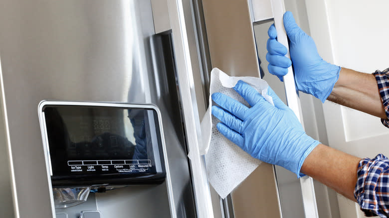 Person cleaning refrigerator door