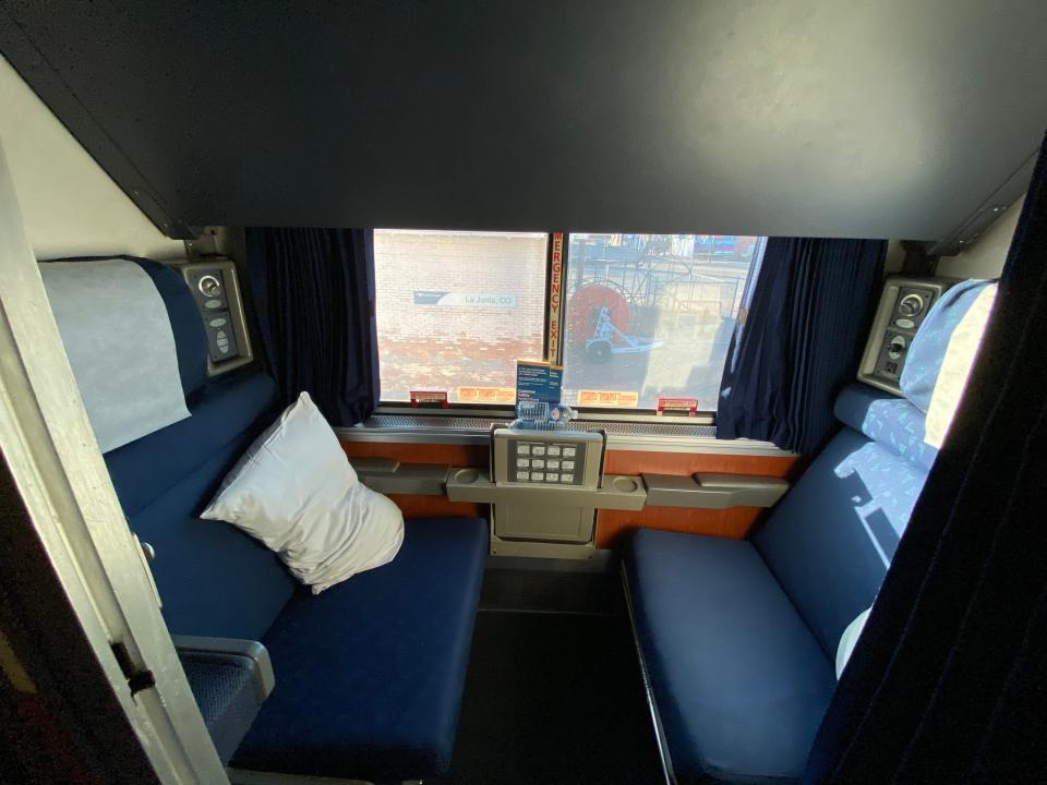 two blue seats in private room with window on amtrak train