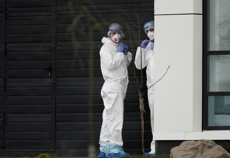 Medical specialists wearing protective gear stand outside a hospital for patients infected with the coronavirus disease on the outskirts of Moscow