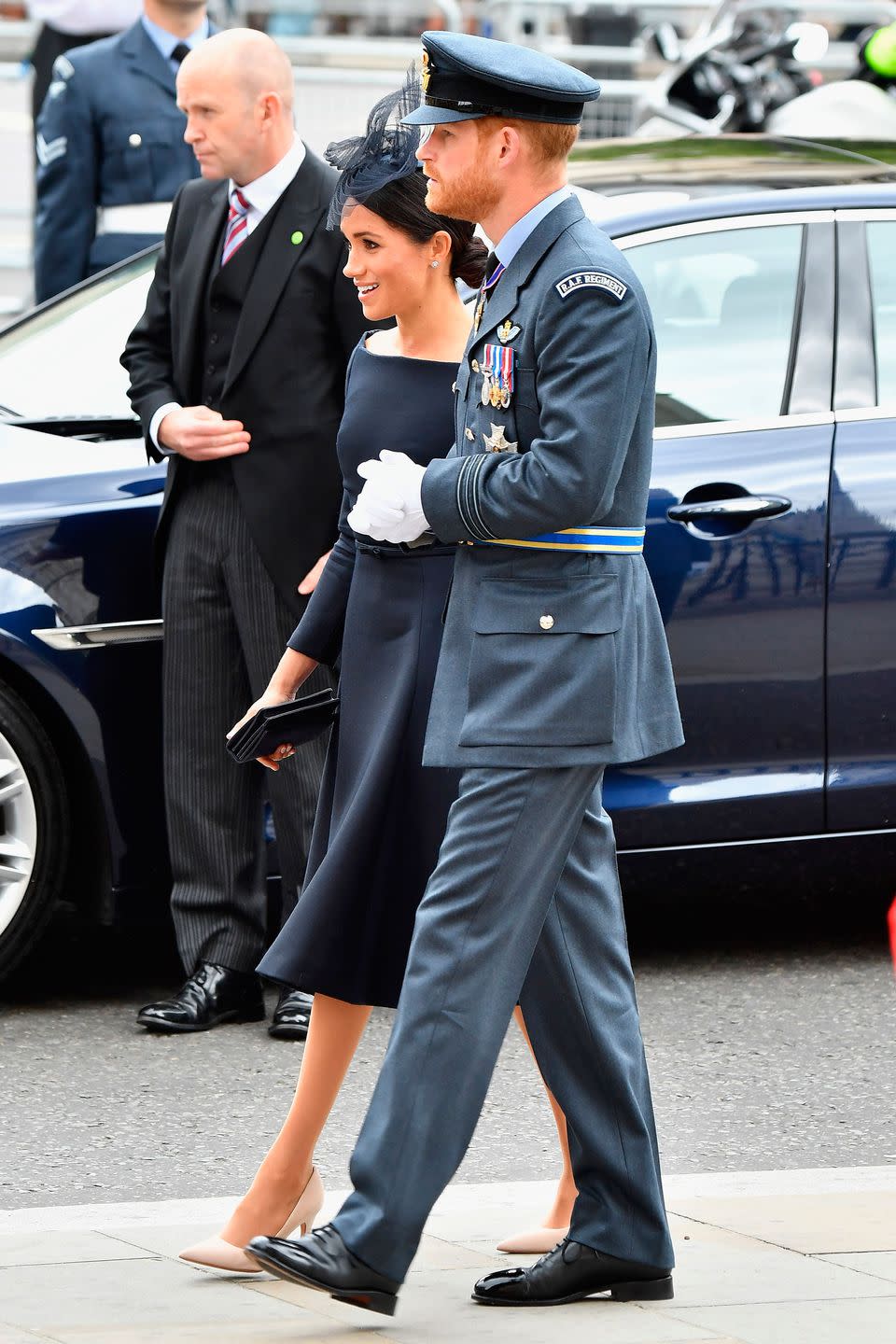 <p>The duchess teamed it with nude heels and a black fascinator, while husband Harry wore his RAF uniform.</p>