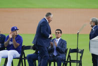 Former Los Angeles Dodgers pitcher Fernando Valenzuela greets Mike Scioscia, standing, during his jersey retirement ceremony before the baseball game between the Dodgers and the Colorado Rockies, Friday, Aug. 11, 2023, in Los Angeles. (AP Photo/Ryan Sun)