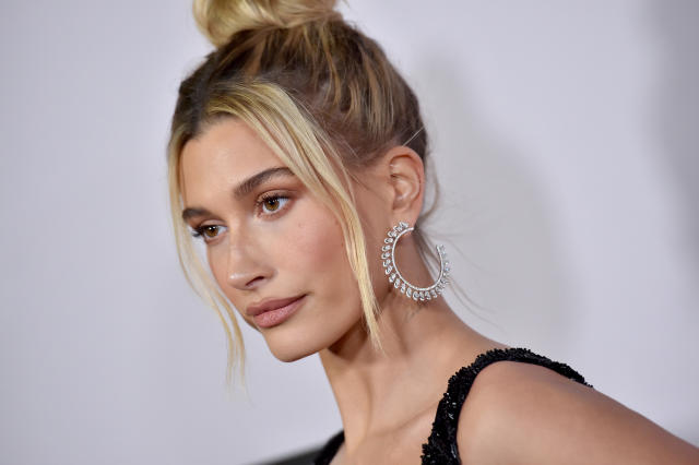 Hailey Bieber rocks a pair of bright orange leggings and sneakers