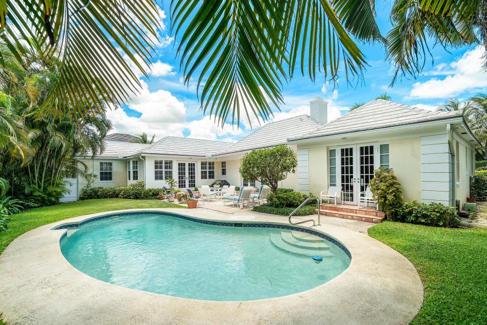 French doors and windows overlook the backyard patio and kidney-shaped pool.