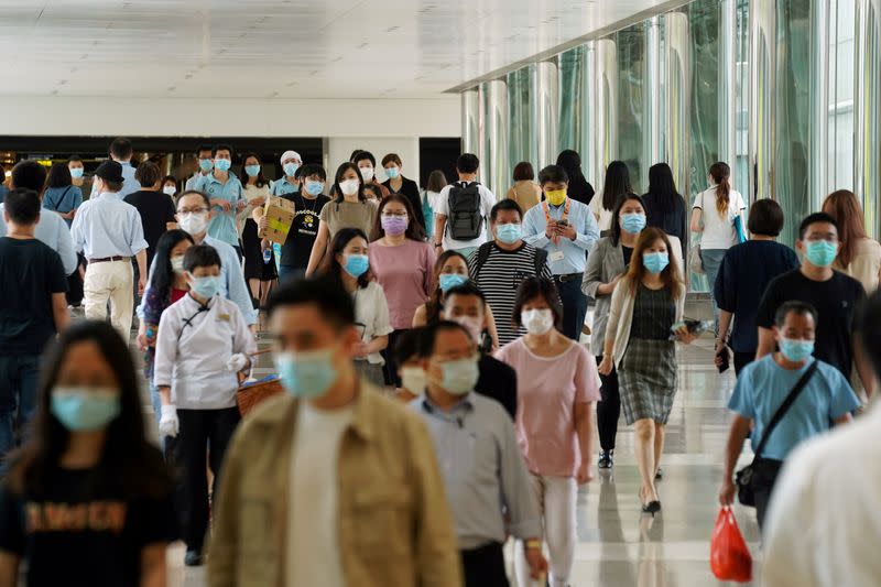 FILE PHOTO: People wearing face masks walk at a shopping mall in Hong Kong