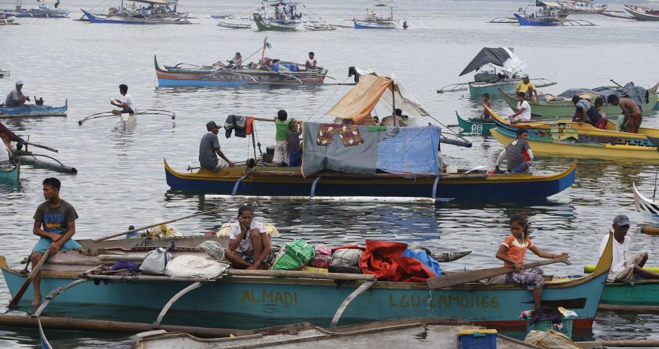 Villagers wait on their boats in Zamboanga port after fleeing their homes due to fighting between the government soldiers and Moro National Liberation Front in downtown Zamboanga city, in southern Philippines September 11, 2013. REUTERS/Erik De Castro (PHILIPPINES - Tags: CIVIL UNREST CONFLICT)