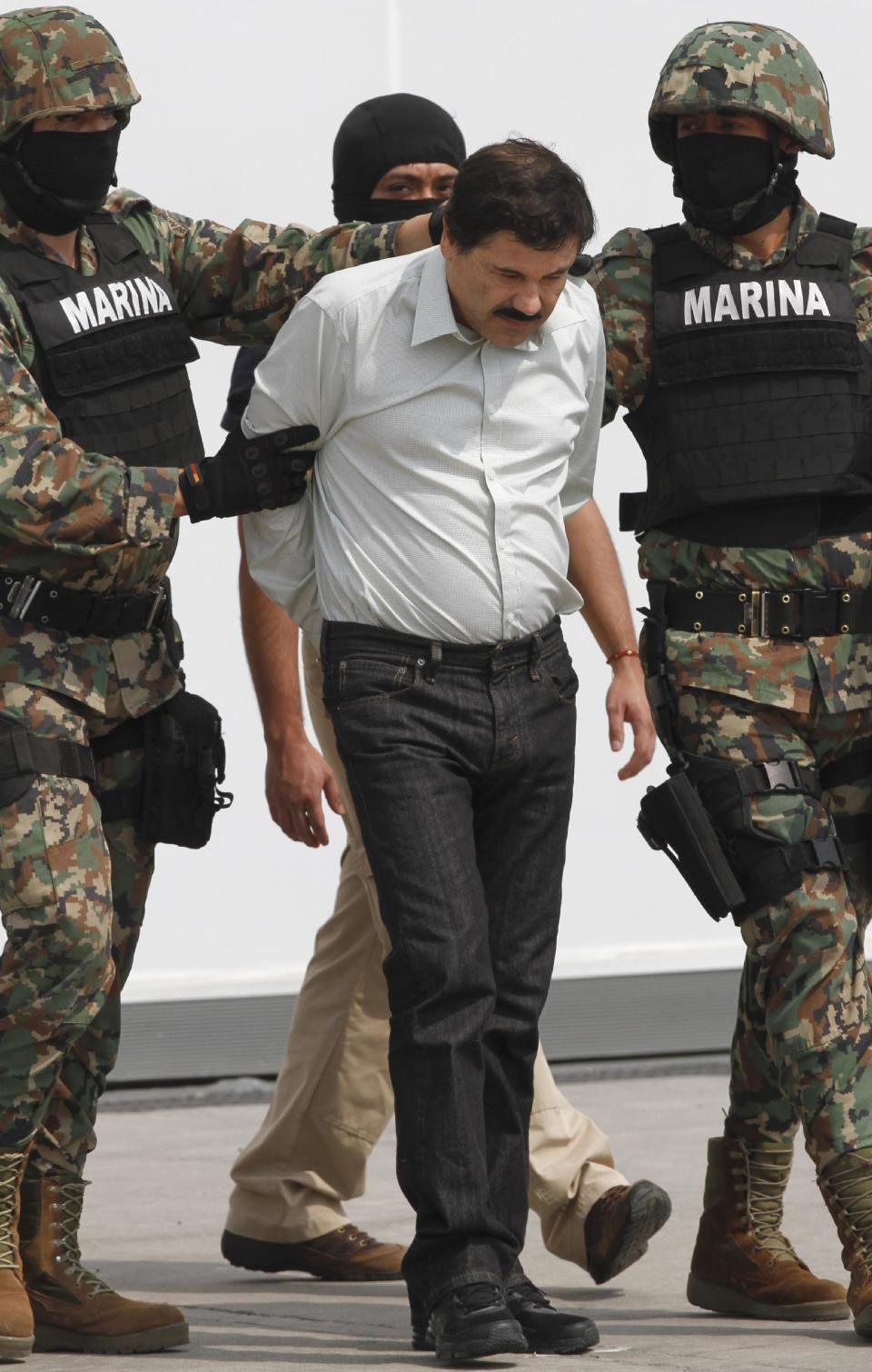 Joaquin "El Chapo" Guzman is escorted to a helicopter in handcuffs by Mexican navy marines at a navy hanger in Mexico City, Saturday, Feb. 22, 2014. A senior U.S. law enforcement official said Saturday, that Guzman, the head of Mexicoís Sinaloa Cartel, was captured alive overnight in the beach resort town of Mazatlan. Guzman faces multiple federal drug trafficking indictments in the U.S. and is on the Drug Enforcement Administrationís most-wanted list. (AP Photo/Marco Ugarte)