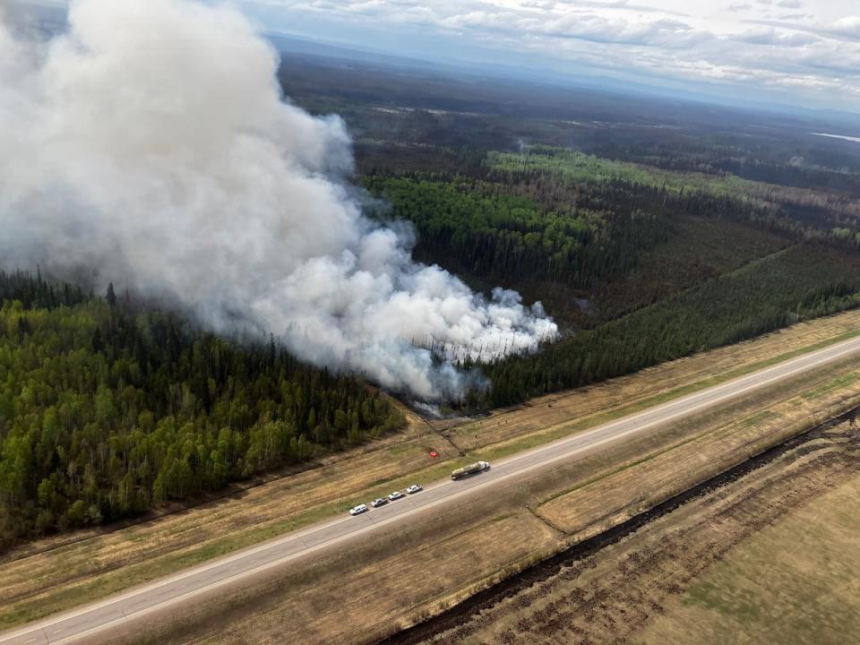 Fire crews are seen performing planned hand ignitions in forests near Fort Nelson, B.C., to limit the growth of the nearby Parker Lake wildfire on May 20.