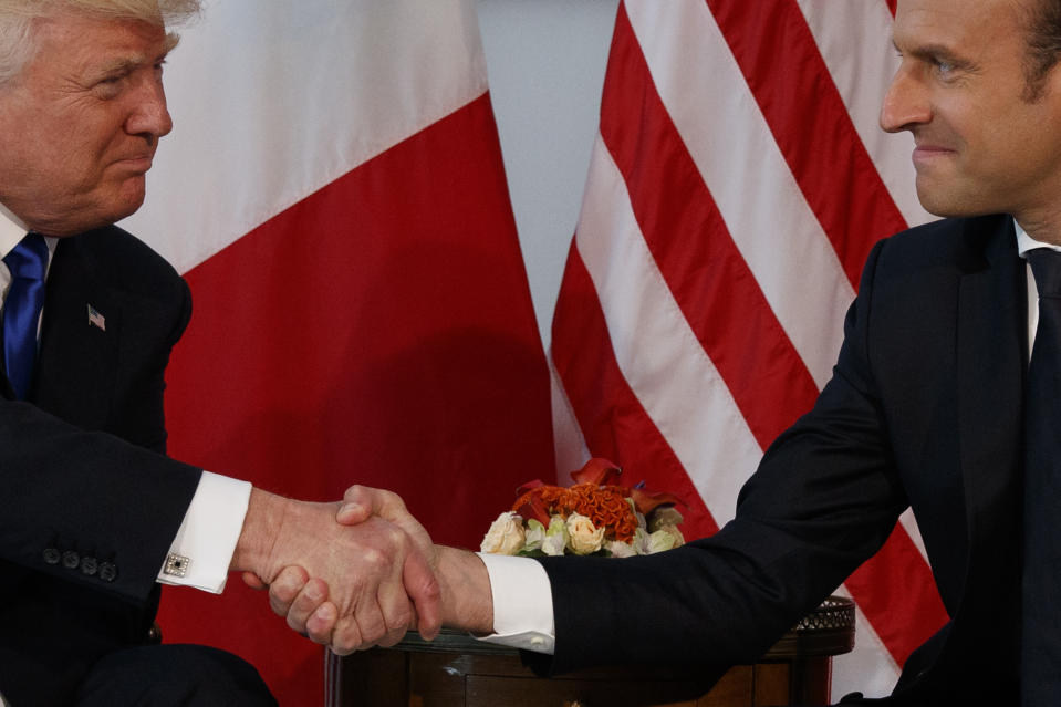 FILE - U.S. President Donald Trump shakes hands with French President Emmanuel Macron during a meeting at the U.S. Embassy in Brussels, May 25, 2017. As Trump becomes the first former president to face federal charges that could put him in jail, many Europeans are watching the case closely. But hardly a single world leader has said a word recently about the man leading the race for the Republican party nomination. (AP Photo/Evan Vucci, File)