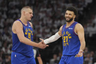 Denver Nuggets center Nikola Jokic (15) and guard Jamal Murray (27) slap hands during the second half of Game 3 of an NBA basketball second-round playoff series against the Minnesota Timberwolves, Friday, May 10, 2024, in Minneapolis. (AP Photo/Abbie Parr)