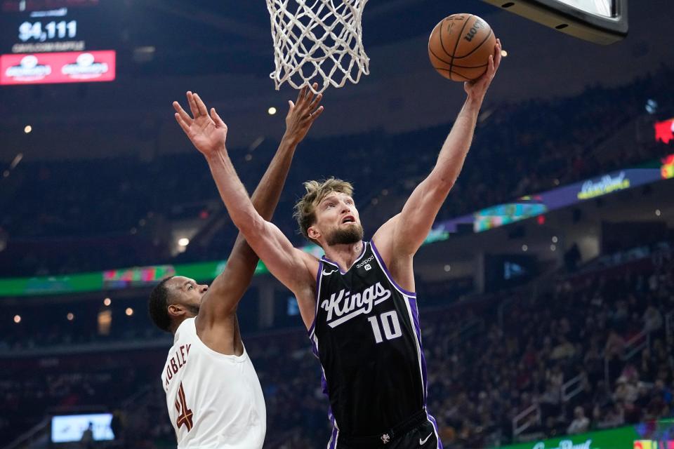 Sacramento Kings forward Domantas Sabonis (10) shoots in front of Cleveland Cavaliers forward Evan Mobley (4) in the first half of an NBA basketball game, Monday, Feb. 5, 2024, in Cleveland. (AP Photo/Sue Ogrocki)