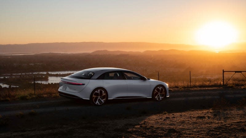 A photo of a white Lucid Air sedan parked at sunset. 