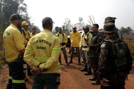 Brazilian soldiers brief firefighters during an operation to combat fires in Amazon jungle in Porto Velho