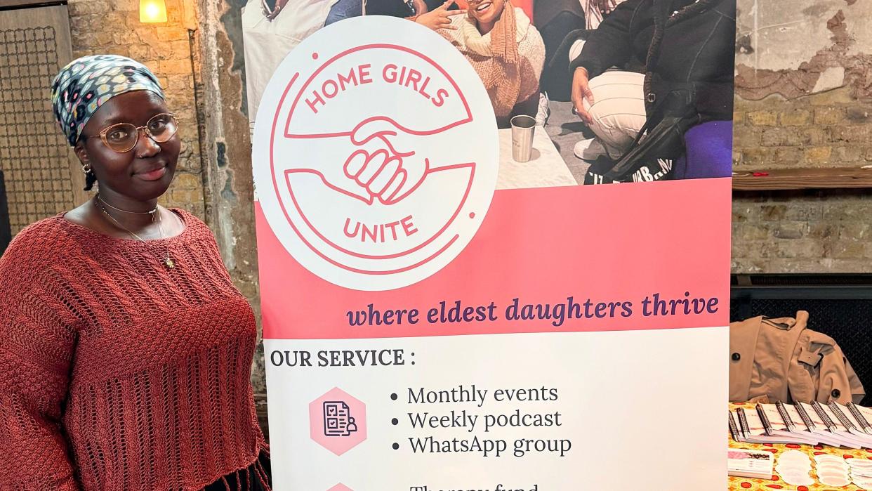 Co-founder Yasin stands next to a Home Girls Unite poster