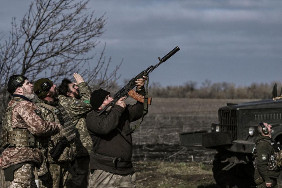 A Ukrainian serviceman fires his rifle at a drone flying above their position near Bakhmut (AFP/Getty)