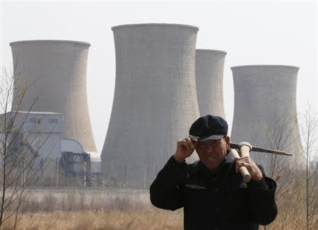 A worker walks past a steel factory in Beijing April 1, 2013. REUTERS/Kim Kyung-Hoon