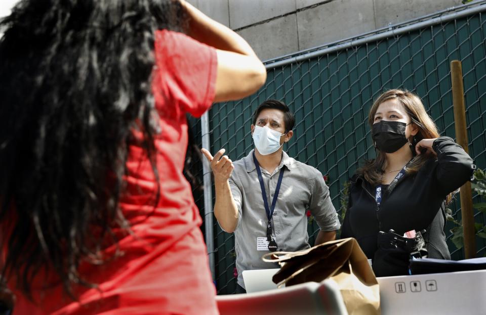 Dr. Siddarth Puri and nurse practitioner Marie Eugenio meet with a participant at Skid Row Community ReFresh Spot.