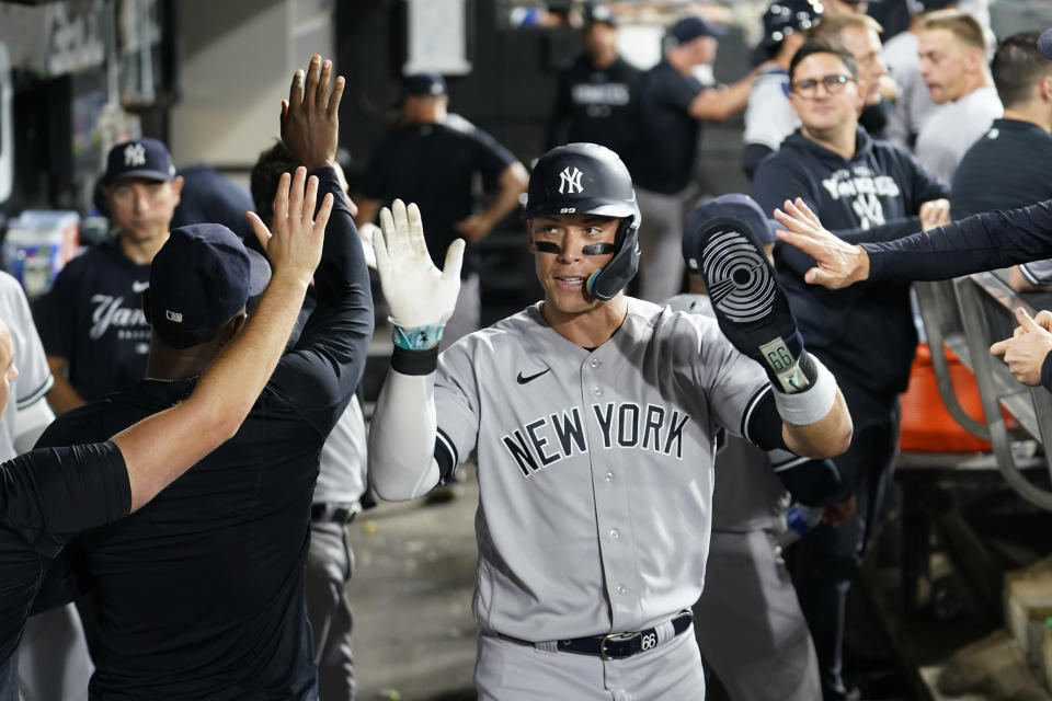 New York Yankees' Aaron Judge celebrates in the dugout after scoring on Billy McKinney's sacrifice fly during the seventh inning of a baseball game against the Chicago White Sox Monday, Aug. 7, 2023, in Chicago. (AP Photo/Charles Rex Arbogast)
