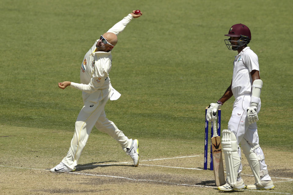 Australia's Nathan Lyon, left, bowls as West Indies' Kragg Brathwaite watches on the 3rd day of their cricket test in Perth, Australia, Saturday, Dec. 3, 2022. (AP Photo/Gary Day)