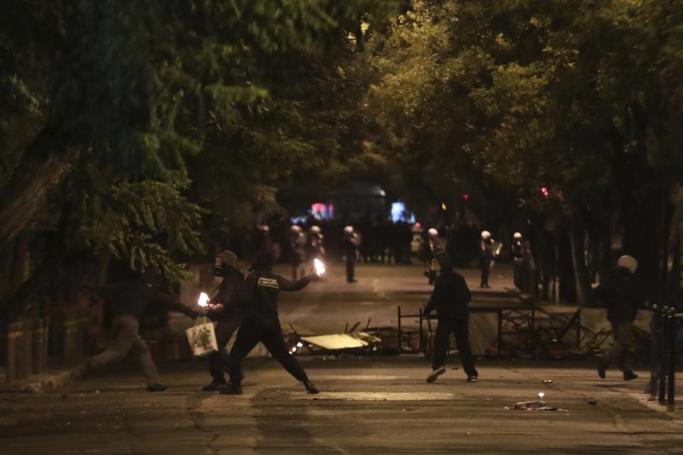 Hooded youths throw petrol bombs at riot police during clashes in the Athens neighborhood of Exarchia, a haven for extreme leftists and anarchists, Saturday, Nov. 17, 2018. Clashes have broken out between police and anarchists in central Athens on the 45th anniversary of a student uprising against Greece's then-ruling military regime. (AP Photo/Yorgos Karahalis)