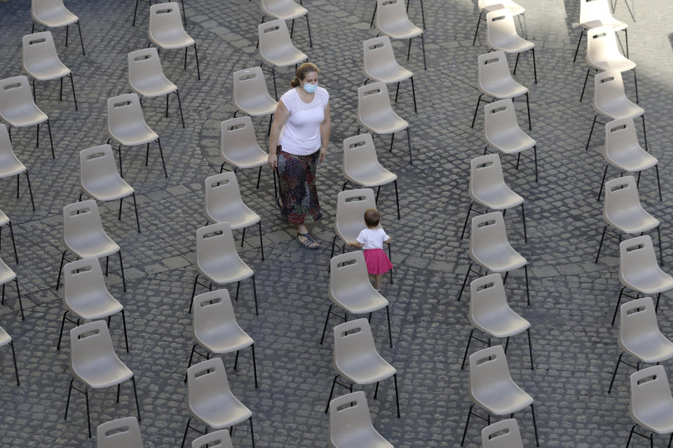 A child plays among empty chairs prior to Pope Francis weekly general audience in San Damaso courtyard at the Vatican, Wednesday, Sept. 9, 2020. (AP Photo/Andrew Medichini)