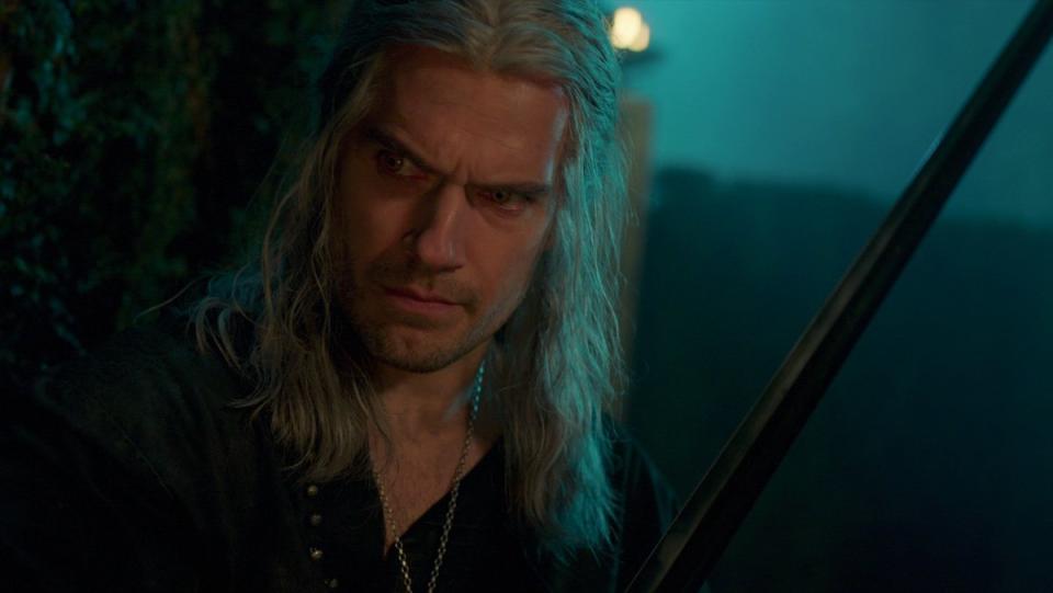 Henry Cavill's Geralt looks stern holding a sword on The Witcher