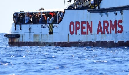 Migrants are seen aboard Spanish migrant rescue ship Open Arms, close to the Italian shore in Lampedusa