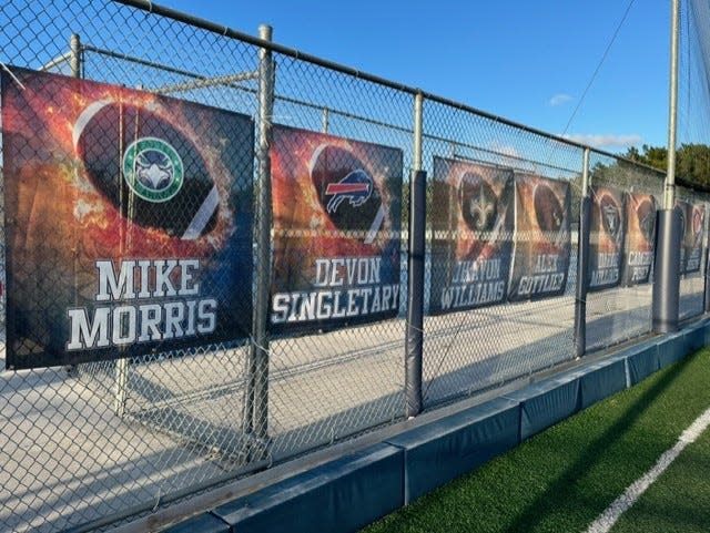 Banners honoring former American Heritage players who made it to the NFL hang on a fence in the north end zone at Scott Maurer Memorial Field.
