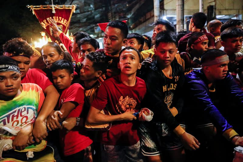 Filipino devotees attempt to get through cops surrounding the route of the Black Nazarene procession during its feast day in Manila