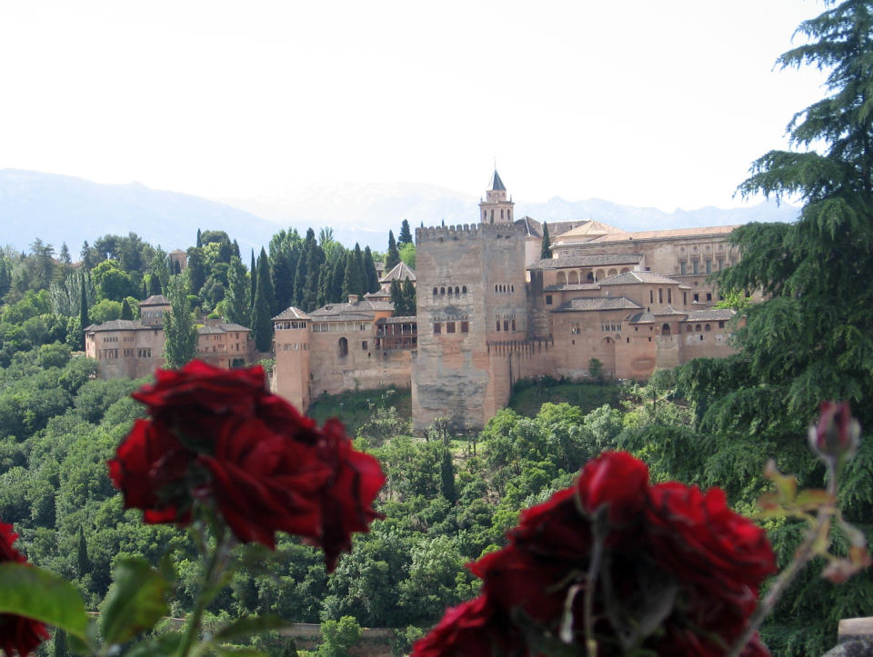 This May 29, 2013 photo shows roses in the garden of a mosque in the Albaicin neighborhood in Granada, in Andalusia, Spain, framing the Alhambra, the city's medieval Islamic palace complex. Andalusia offers a fusion of Christian and Islamic cultures, found in architectural masterpieces and in everyday life. (AP Photo/Giovanna Dell’Orto)