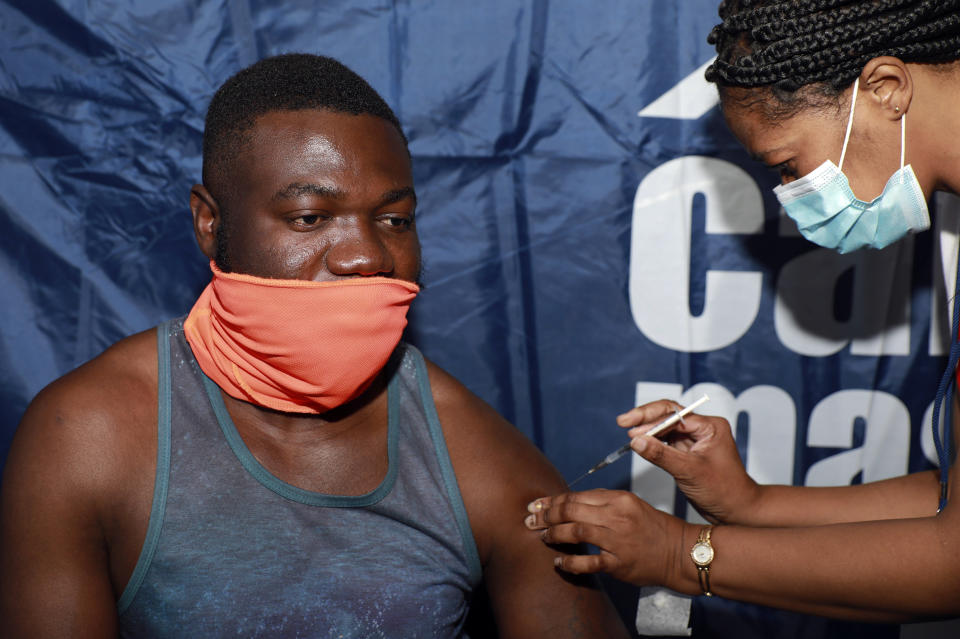 33-year-old Noesqui Muanza receives a dose of the Pfizer COVID-19 vaccine at the Vaccination Centre of Hope at the Cape Town International Convention Centre in Cape Town, South Africa, Friday, Dec. 3, 2021. The mass Covid-19 vaccination site is closing today after vaccinating more than 136 000 people at the Western Cape's first mass vaccination centre. (AP Photo/Nardus Engelbrecht)