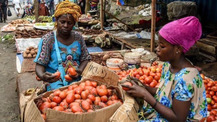 Vendors clean tomatoes on Mabibo Street without without wearing masks despite the confirmed COVID-19 coronavirus cases in Dar es Salaam, Tanzania, on April 16, 2020