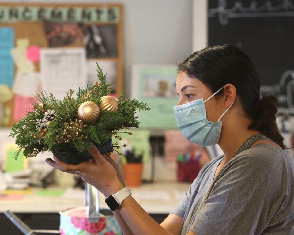 Student Kiara Benavides prepares a centerpiece, one of the items available during the annual Poinsettia Sale at Cal Poly. She was working Dec. 1, 2021, just a few days before the sale opened.